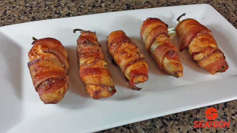 A photograph of bacon wrapped, Chilean crab meat stuffed jalapeno poppers.
