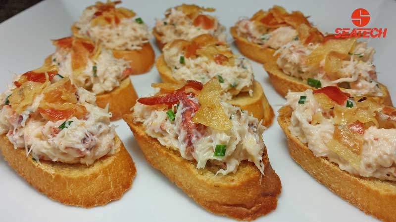 A photograph of crab salad bruschetta topped with crisped pancetta.